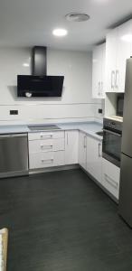 a kitchen with white cabinets and a stove top oven at ALTOZANO in Albacete