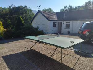 a ping pong table in front of a house at Craignavie Cottage in Killin