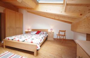 a bedroom with a bed in a room with wooden ceilings at Casa Seler - Appartamento rosso in Predazzo