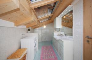 プレダッツォにあるCasa Seler - Appartamento rossoの木製の天井のバスルーム(白い洗面台付)