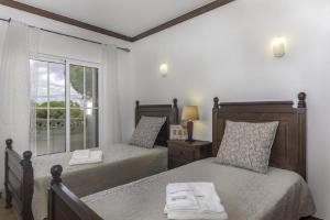 a bedroom with two beds and a window with a view at Seaview Terrace Benagil Villa 45 in Benagil