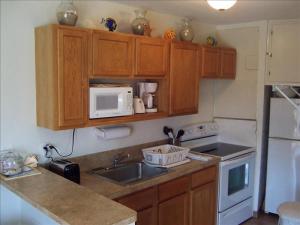 a kitchen with wooden cabinets and a sink and a microwave at La Internacional Condos O211 in South Padre Island