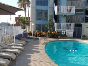 - une piscine avec des chaises longues à côté d'un bâtiment dans l'établissement La Internacional Condos O211, à South Padre Island