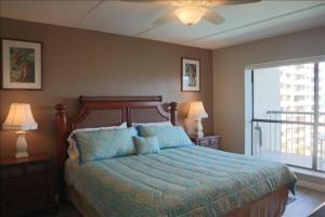 a bedroom with a bed and two lamps and a window at Saida III Condos S3805 in South Padre Island