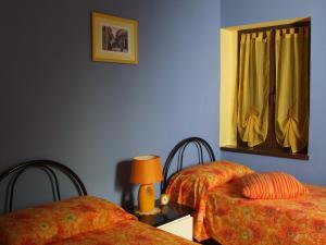 1 dormitorio con 2 camas y espejo en la pared en B&B Il Campo dei Papaveri, en Mornese