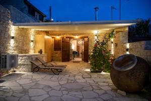 a patio at night with a bench and lights at Apanemia Inn Studio in Lofou