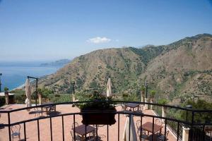a balcony with a view of the ocean and mountains at Agostiniana Hotel in Forza dʼAgro