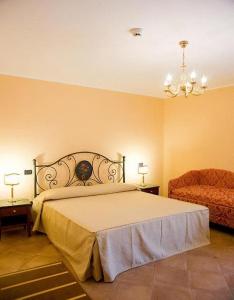 a bedroom with a bed and a chair at Agostiniana Hotel in Forza dʼAgro