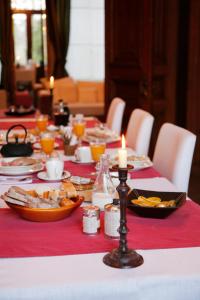 スタヴロにあるB＆B ベル ナチュラ クエット エ カフェの赤いテーブルクロスとキャンドルが掛けられたテーブル
