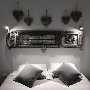 a bed with a headboard with hearts on the wall at Casinhas do Canário in Montoito +50 photos