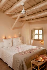 Un dormitorio con una gran cama blanca con flores. en Arkhé Hotel Boutique Pals, en Pals