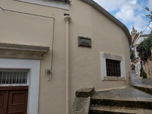 - un bâtiment blanc avec une porte et une fenêtre dans l'établissement Casa Mavì Limite delle due Matrici, à Modica
