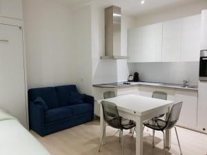 a kitchen with a table and chairs and a blue couch at Blu's Apartment sul Talvera in Bolzano