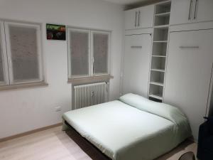 a small bedroom with a bed and some windows at Blu's Apartment sul Talvera in Bolzano