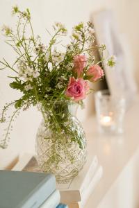 un jarrón lleno de rosas rosas sentadas en una mesa en Arkhé Hotel Boutique Pals en Pals