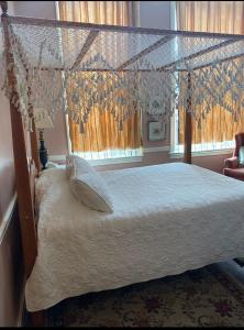 a bedroom with a canopy bed and a window at Leesburg Colonial Inn in Leesburg