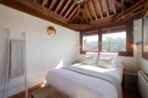a bedroom with a large white bed with a window at Casa Bombo in Granada