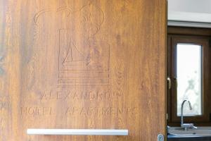 a wooden door with a sign that reads alamedaolis hotel appliance at Alexandros Hotel Apartments in Vourvourou