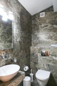 a bathroom with a sink and a toilet at Alexandros Hotel Apartments in Vourvourou