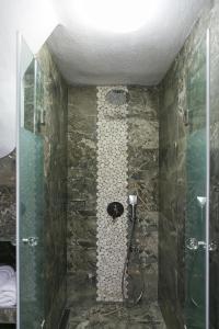 a bathroom with a shower with a glass door at Alexandros Hotel Apartments in Vourvourou