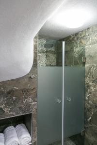 a shower with a glass door in a bathroom at Alexandros Hotel Apartments in Vourvourou