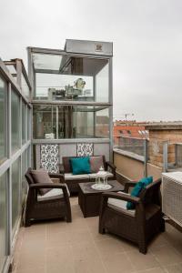 a balcony with chairs and tables on a roof at Grand Budapest Apartments in Budapest