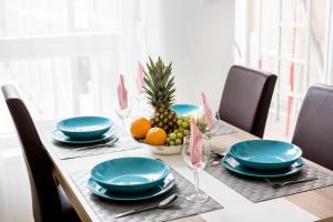 einen Tisch mit blauen Tellern und einer Schale Obst in der Unterkunft Grand Budapest Apartments in Budapest
