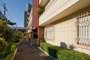 a sidewalk next to a building with a fence at Perto Consulado Americano Ar QUENTE 2 quartos Até 6 pessoas Av Carlos Gomes não tem garagem in Porto Alegre