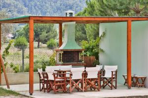 a group of chairs and a table and a fireplace at Alexandros Hotel Apartments in Vourvourou