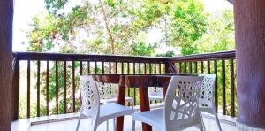 a porch with a table and chairs on a balcony at Excelentes apartamentos Barra Bali in Barra de São Miguel