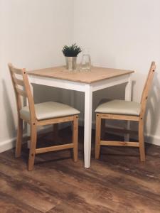 a table with two chairs and a table with a plant on it at La Maison d'Ange in Le Hohwald
