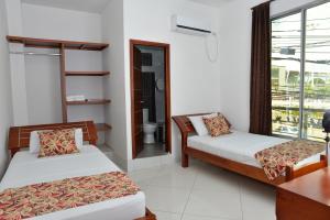 a room with two beds and a window at Hotel Canoa Inn in Caucasia