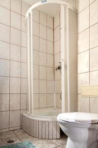 een badkamer met een douche en een toilet. bij Hotel Beta in Cluj-Napoca