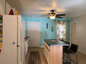 a kitchen with a ceiling fan and a refrigerator at My Ohana - 30 days in Kailua-Kona