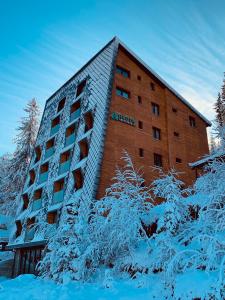 a building with snow on the ground in front of it at Apartment A5 Lux in Jahorina