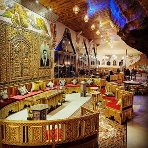 a restaurant with tables and couches in a room at Memories Aicha Luxury Camp in Wadi Rum