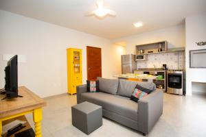 a living room with a couch and a kitchen at Barra Holiday Apartamentos in Florianópolis