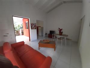 uma sala de estar com um sofá vermelho e uma mesa em Chez JUJU em Le Gosier