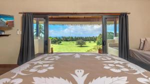 a bedroom with a bed and a large window at Rainbow Villas in Rarotonga