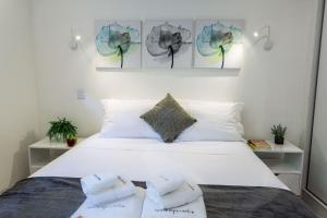 a bedroom with a white bed with two pillows at Apartamento com quintal em Alto de Pinheiros in Sao Paulo