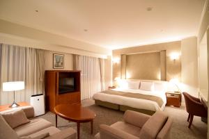 a hotel room with a bed and a television at Hotel Sankyo Fukushima in Fukushima +58 photos