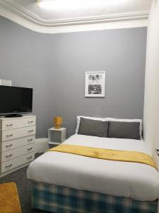 a bedroom with a bed and a flat screen tv at TOPAZ TOWN HOUSE No 36 in Huddersfield