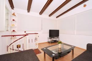 een woonkamer met een tv en een glazen tafel bij Apartment Irvin - sweet apartment in Trogir
