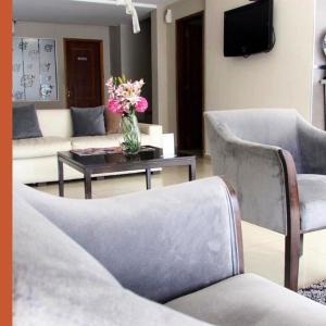 a living room with a couch and a table with flowers at Hotel Los Naranjos in General Deheza