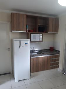 una cucina con frigorifero bianco e forno a microonde di Thermas Lacqua Diroma Caldas Novas a Caldas Novas