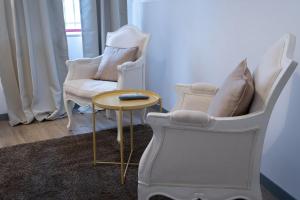 a living room with two chairs and a table at Portas da Vila in Miranda do Douro +7 photos