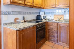a kitchen with wooden cabinets and a stove top oven at Portas da Vila in Miranda do Douro