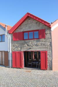 a building with red doors and a red roof at Casa do Mar in Vila Chã