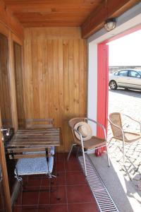 a porch with a bench and a table and chairs at Casa do Mar in Vila Chã