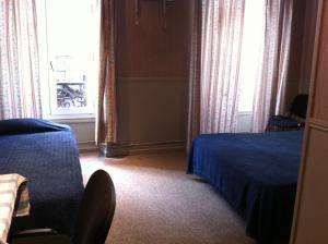 パリにあるホテル デザールのベッドと窓が備わるホテルルーム